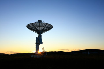 The silhouette of a radio telescope