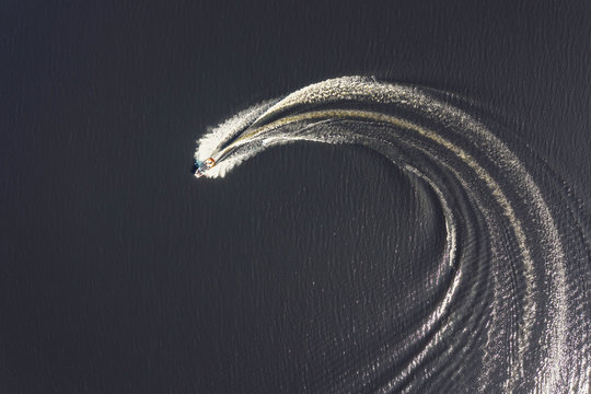Aerial overhead shot of a small motor boat turning, taken in May 2019