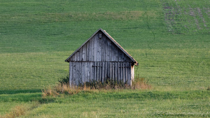 Obraz premium small wooden barn in a field