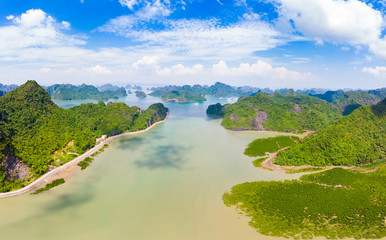 Aerial view of Ha Long Bay Cat Ba island, unique limestone rock islands and karst formation peaks in the sea, famous tourism destination in Vietnam. Scenic blue sky.