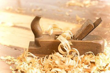 Old wooden hand plane for woodworking with wood shavings.