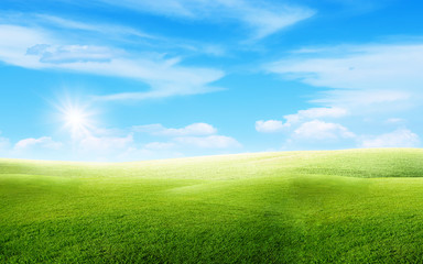 Fototapeta na wymiar Beautiful landscape view of Green grass natural meadow field and little hill with white clouds and blue sky in summer seasonal.