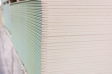 Gypsum plasterboard in the pack. The stack of gypsum board preparing for construction. Pallet with...