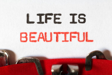 Life is beautiful typed on typewriter on red and black