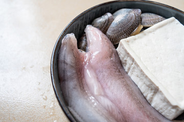 Obraz premium A bowl of fresh ingredients for making soup, fish buds and tofu
