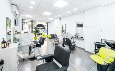Panorama of a modern bright hair and beauty salon. Barber salon interior business with black and...