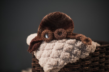Empty fairytale crib with a soft plaid and knitted baby hat