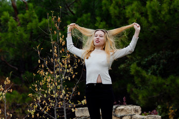 beautiful girl stands on stone wall
