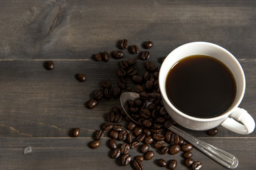 Cup of Coffee with coffee beans close up photo on wooden background