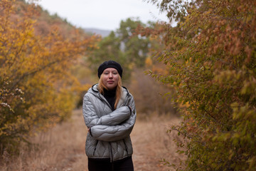 Girl feels cold in autumn park.