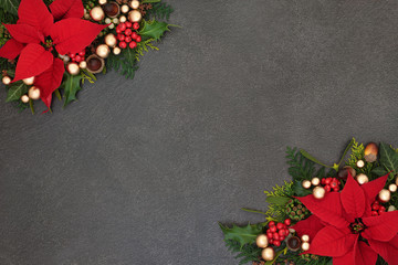 Poinsettia flower background border with winter flora and gold bauble decorations on grunge grey....