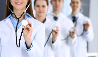 Group of doctors holding stethoscope head close-up. Physicians ready to examine and help patient. Medical help, insurance in health care, best treatment and medicine concept