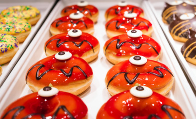 Sweets and desserts for the Halloween party. Donuts in the form of scary monsters. Candy bar.