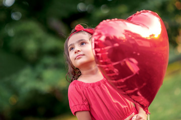 Little happy girl with balloon outdoor