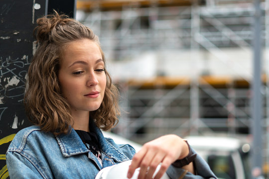 Thoughtful and contemplative factory female employee resting during the work break outdoors
