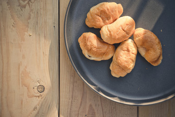Croissants on a plate. Bakery products. Plate on a wooden background. Baking on a plate.