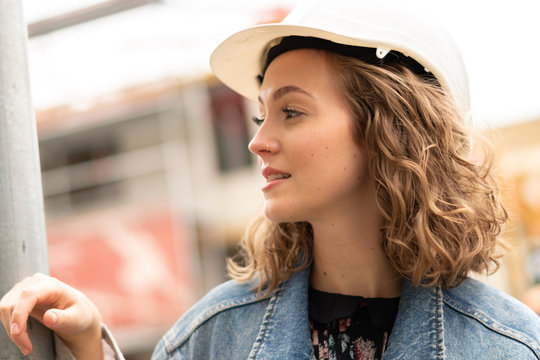 Thoughtful and contemplative factory female employee resting during the work break outdoors