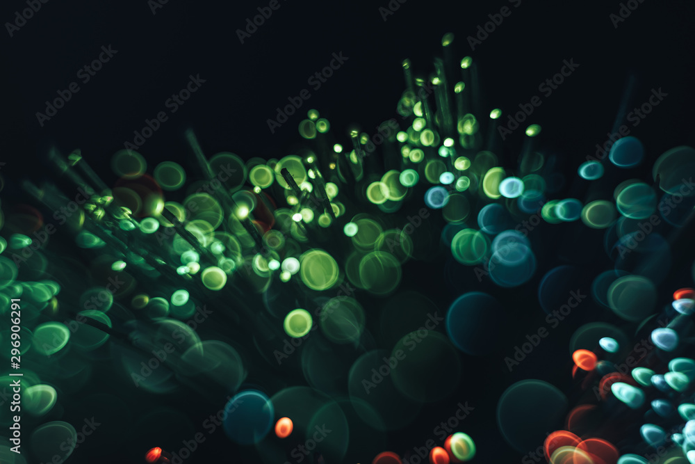 Poster beautiful abstract fiber optical network cable on a multi colored glow background.