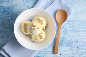 vanilla ice cream and candy on a blue background with a blank space for a text, vanilla ice cream in white ceramic cup