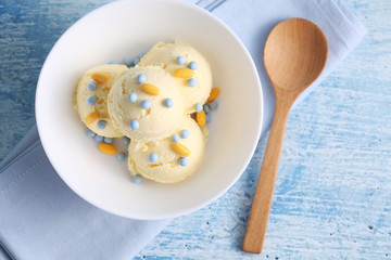 vanilla ice cream and candy on a blue background with a blank space for a text, vanilla ice cream in white ceramic cup