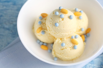 vanilla ice cream and candy on a blue background with a blank space for a text, vanilla ice cream in white ceramic cup