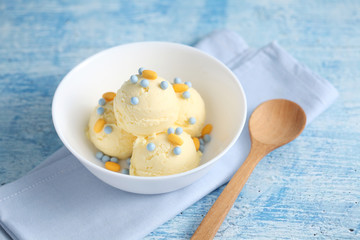 vanilla ice cream and candy on a blue background with a blank space for a text, vanilla ice cream in white ceramic cup