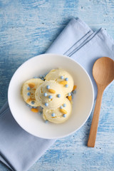 vanilla ice cream and candy on a blue background with a blank space for a text, vanilla ice cream in white ceramic cup