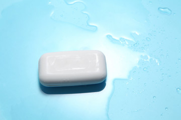 white soap and water drop on a blue background with a blank space for a text, shower accessories in top view