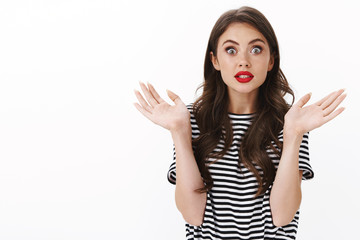 Enthusiastic thrilled young fashionable caucasian woman gesturing surprised and emotive, stare...