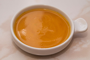 bowl with pumpkin soup on background