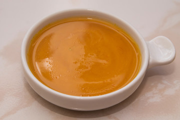 bowl with pumpkin soup on background