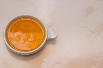 bowl with pumpkin soup on background