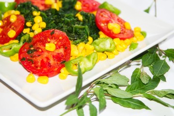 plate of tomato and spinach salad close-up view, diet and health concept