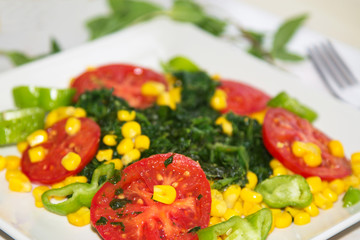 plate of tomato and spinach salad close-up view, diet and health concept