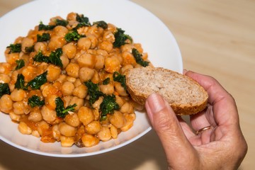 holding plate of chickpeas and spinach, diet and food concept