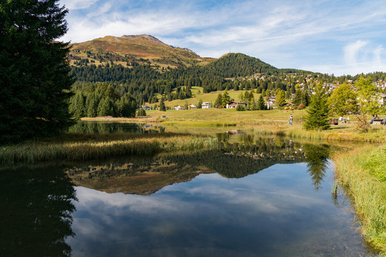 village of Valbella reflected in mountain lake in the Swiss Alps