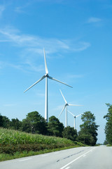 wind turbines line the side of a country road