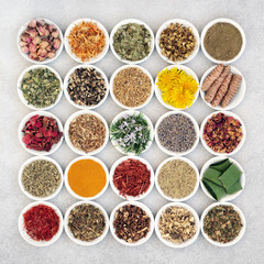 Herb and spice collection used for skin care for anti ageing and to help soothe and heal various skin conditions including acne, eczema & psoriasis. In porcelain bowls. Flat lay. 