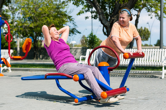 Two senior woman training on outside playground.