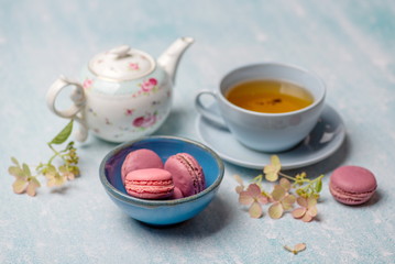 Fototapeta na wymiar pink macaroons with teapot and Cup