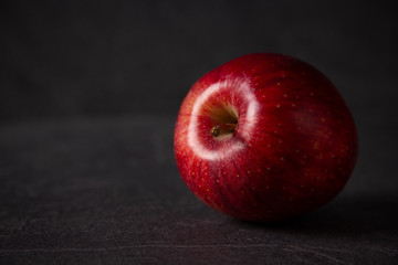 red apple against black stone background with space for text