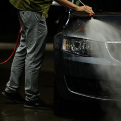 Car close-up. Car wash. Manual car wash with pressurized water in car wash outside. 