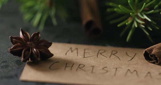 Slow motion fly out from merry christmas card to spruce twig