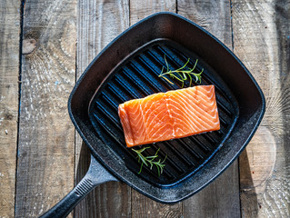 Fresh raw salmon fish served on cast iron grill pan