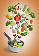 Fresh vegetables flying in a pot, isolated on orange background - image