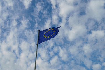 Flag of Europe (blue background and twelve five -pointed yellow stars). Flags blowing on the wind in a sunny summer day. Flags against blue sky background.