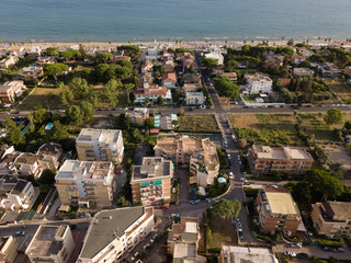 Obraz premium Top view of a coastal town with a beach and beach umbrellas. Terracina, Province of Latina, Lazio Region, Italy