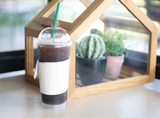 Closeup glass of ice americano on wood table in coffee shop