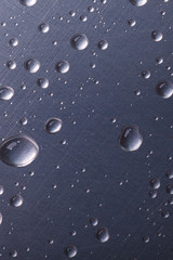 dots of water on dark metal surface, macro background, vertical shot
