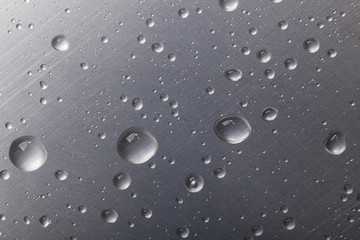 dots of water on dark metal surface, macro background, horizontal shot